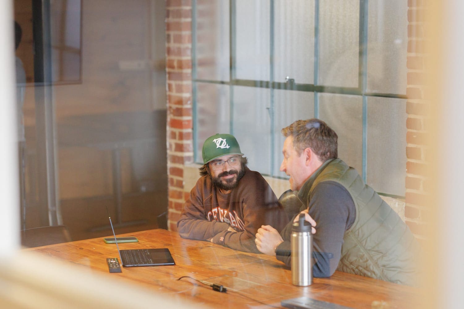Two CloudConnex coworkers collaborating during a strategy session in a glass-walled conference room