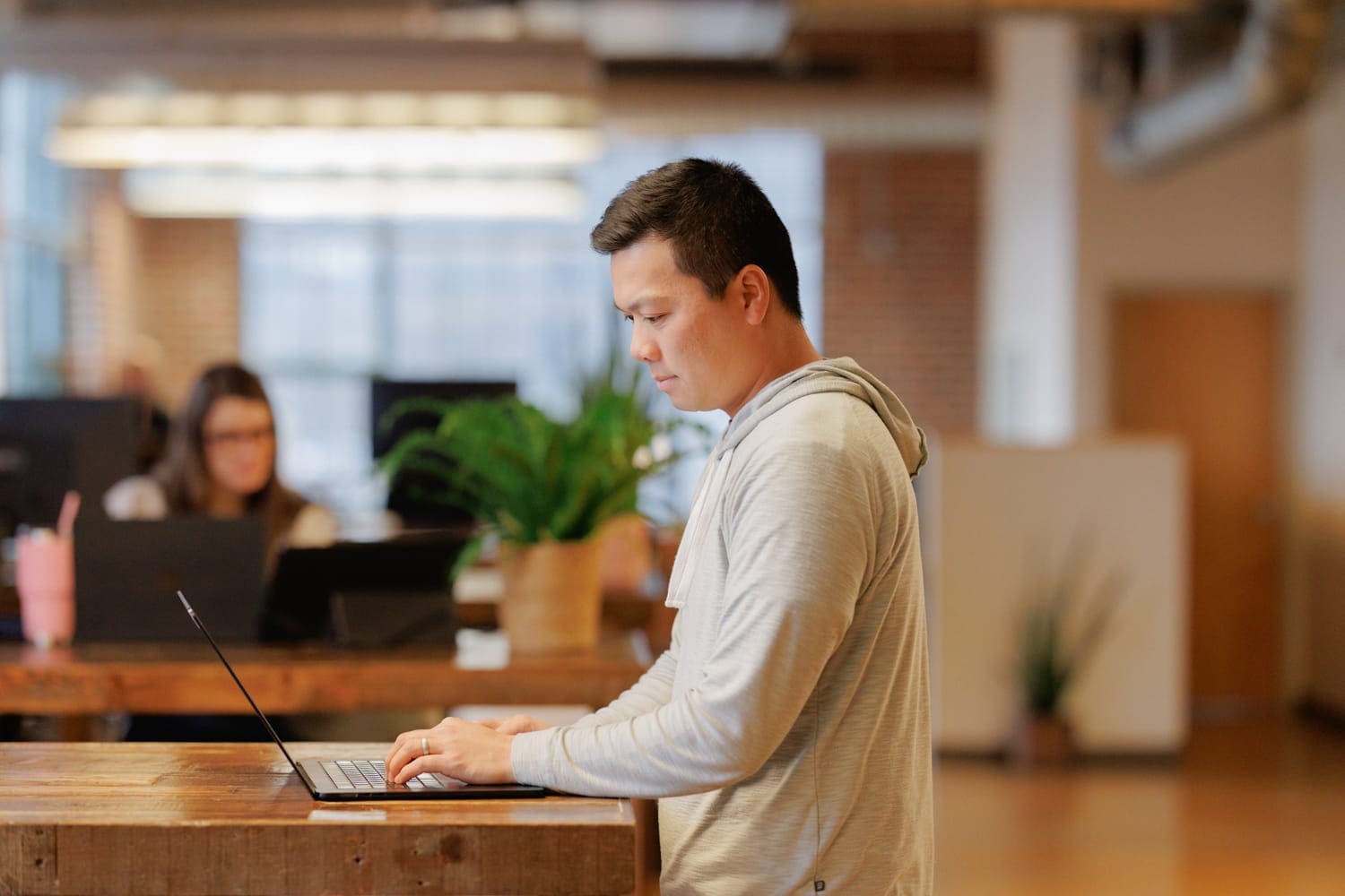 Focused Cloud Connex team member typing on laptop in workspace