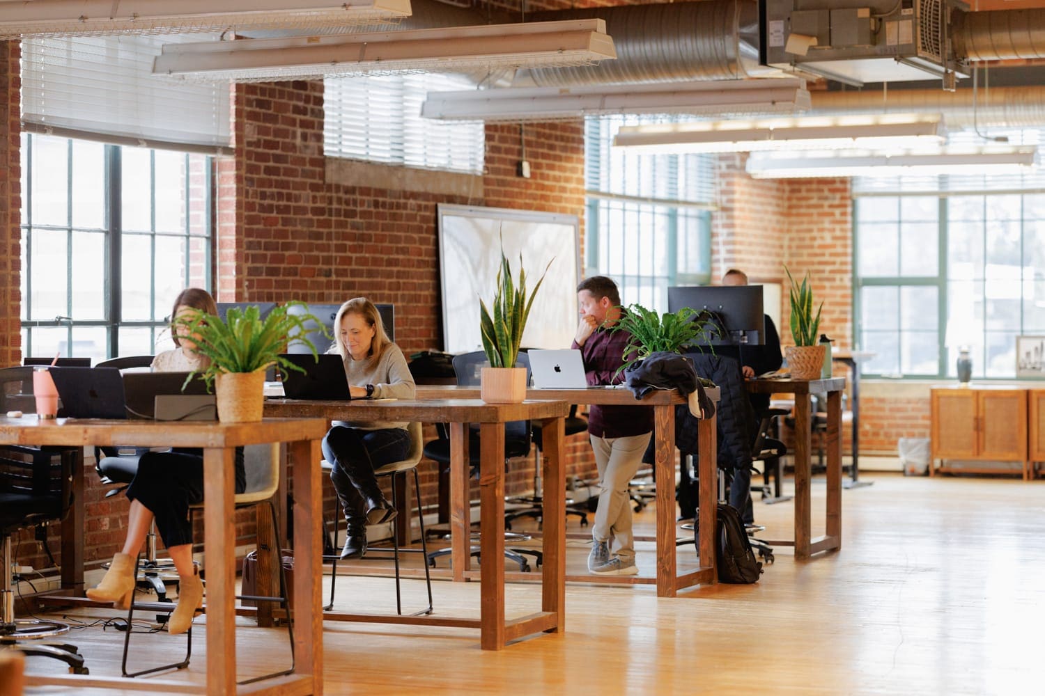 CloudConnex employees working across shared desks in an open-concept tech office environment