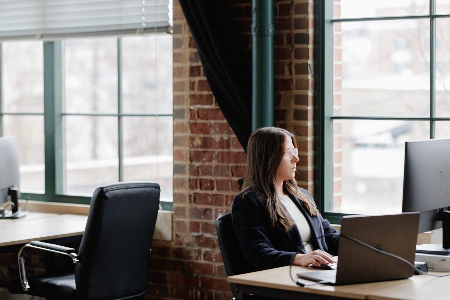 CloudConnex team member working intently at a modern desk in a tech-forward, minimalist workspace