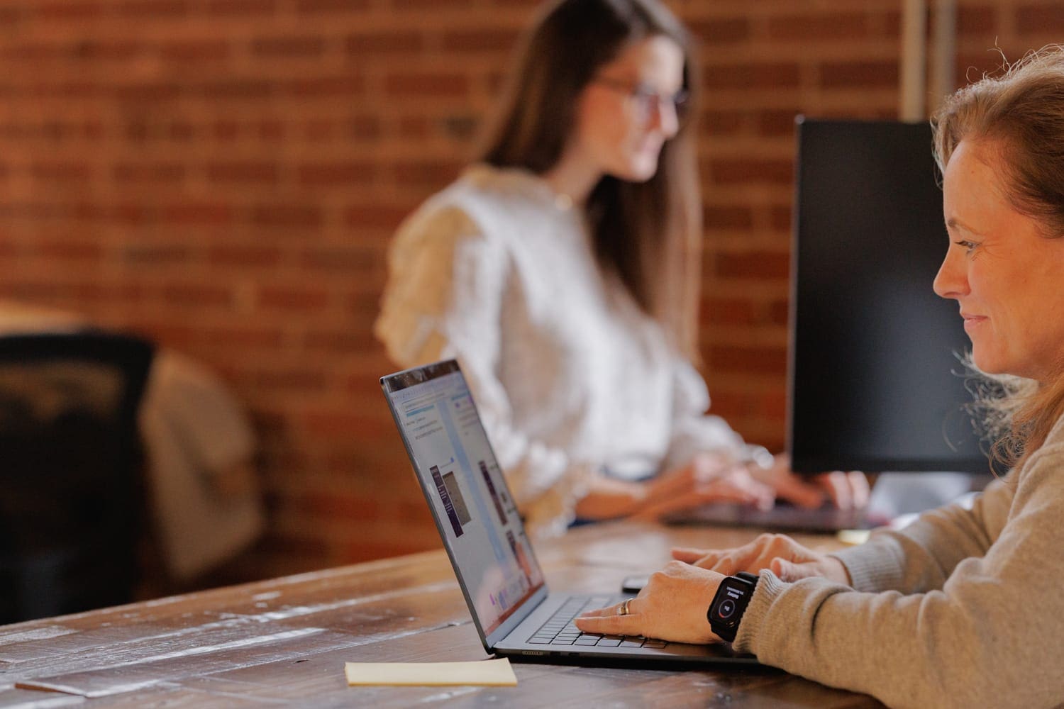 CloudConnex team member working remotely on a laptop in a modern, tech-enabled workspace